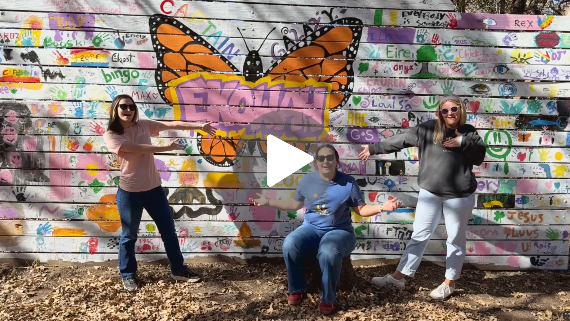 Three staff members of Girl Scout stand in front of a mural full of art with a big butterfly on it and the words Camp Ekowah. It's a video thumbnail to watch a video of a tour.